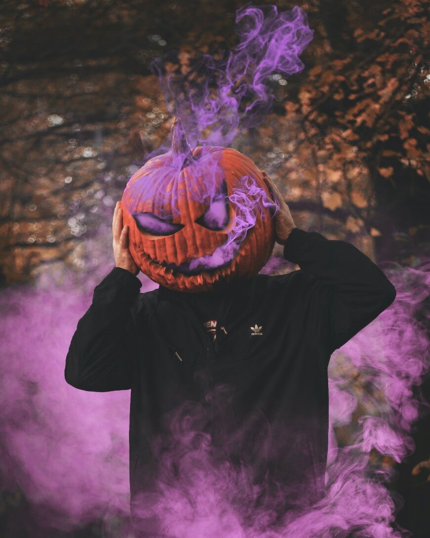 adult trick or treater wearing halloween pumpkin mask