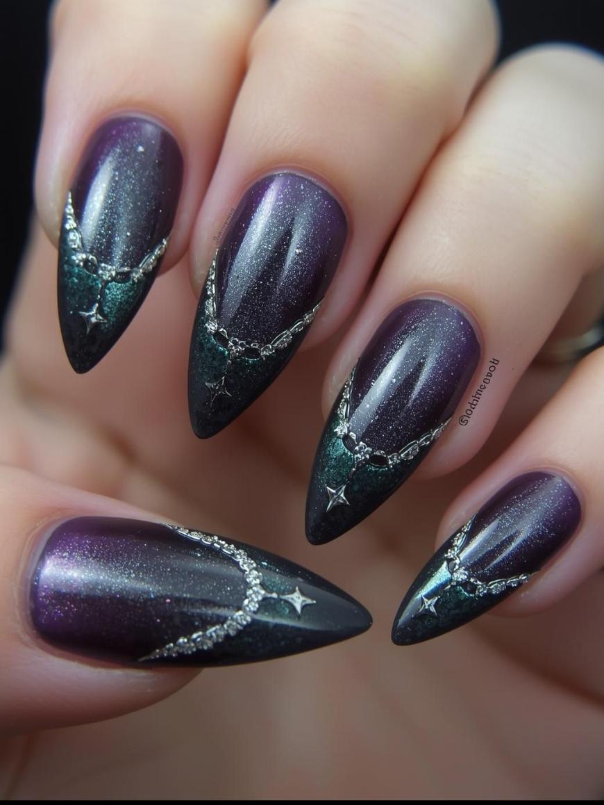 A close-up of hands with long, almond-shaped nails painted in a shimmery purple-to-black gradient, featuring silver star and chain-like designs on each nail.