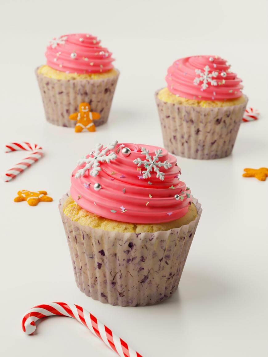Three cupcakes with pink frosting, decorated with snowflakes and silver sprinkles, are surrounded by candy canes and small gingerbread figures on a white surface.