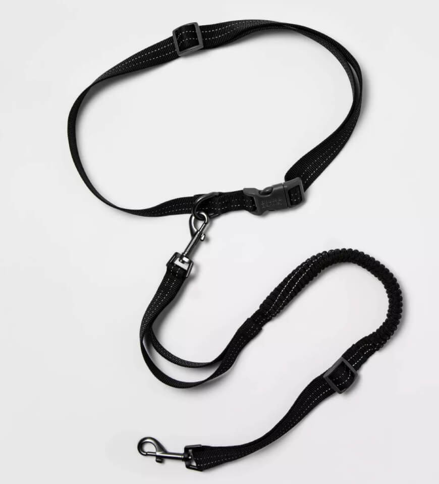 A black adjustable dog leash with a buckle, metal clip, and elastic bungee section, arranged on a plain white background.