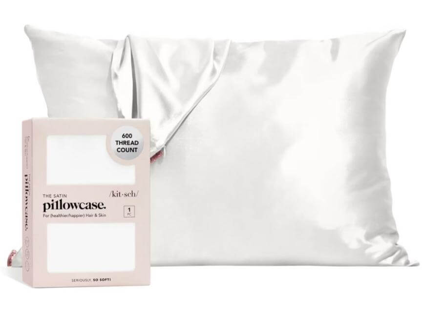 A shiny white satin pillowcase with a matching box labeled The Satin Pillowcase and 600 Thread Count placed in front of it.