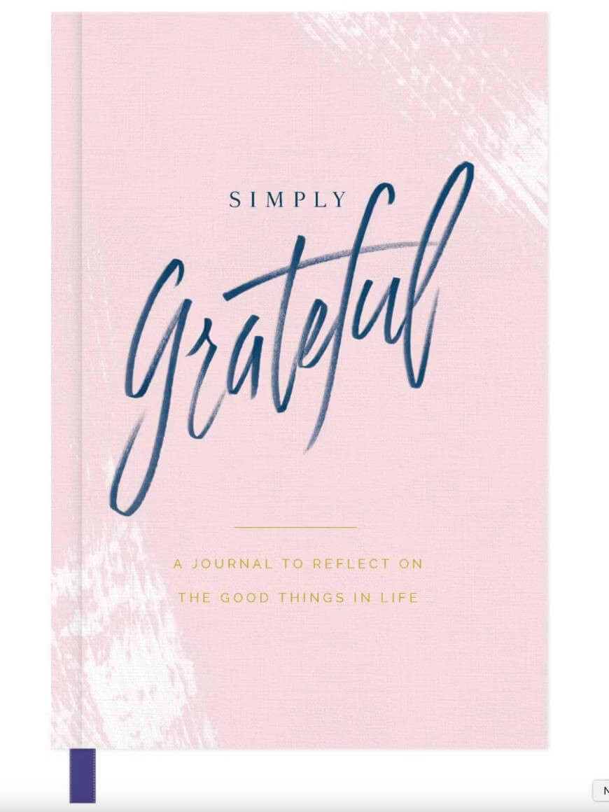 A pink journal cover with the words Simply Grateful in large, blue script and A journal to reflect on the good things in life in smaller, gold capital letters below. A purple ribbon marks the spine.