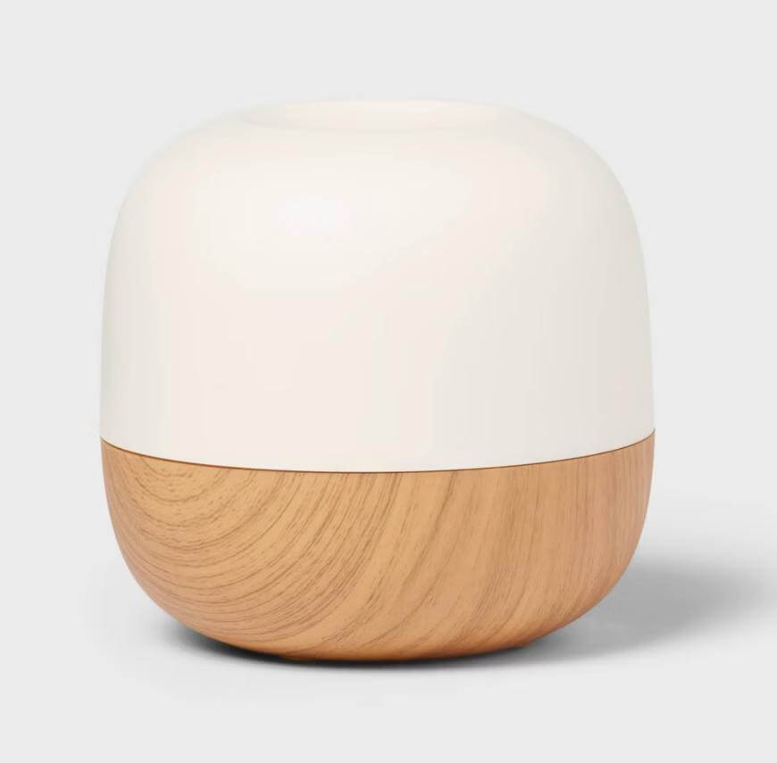 A small, rounded container with a smooth, matte white top half and a light wood-grain bottom half, set against a plain light gray background.