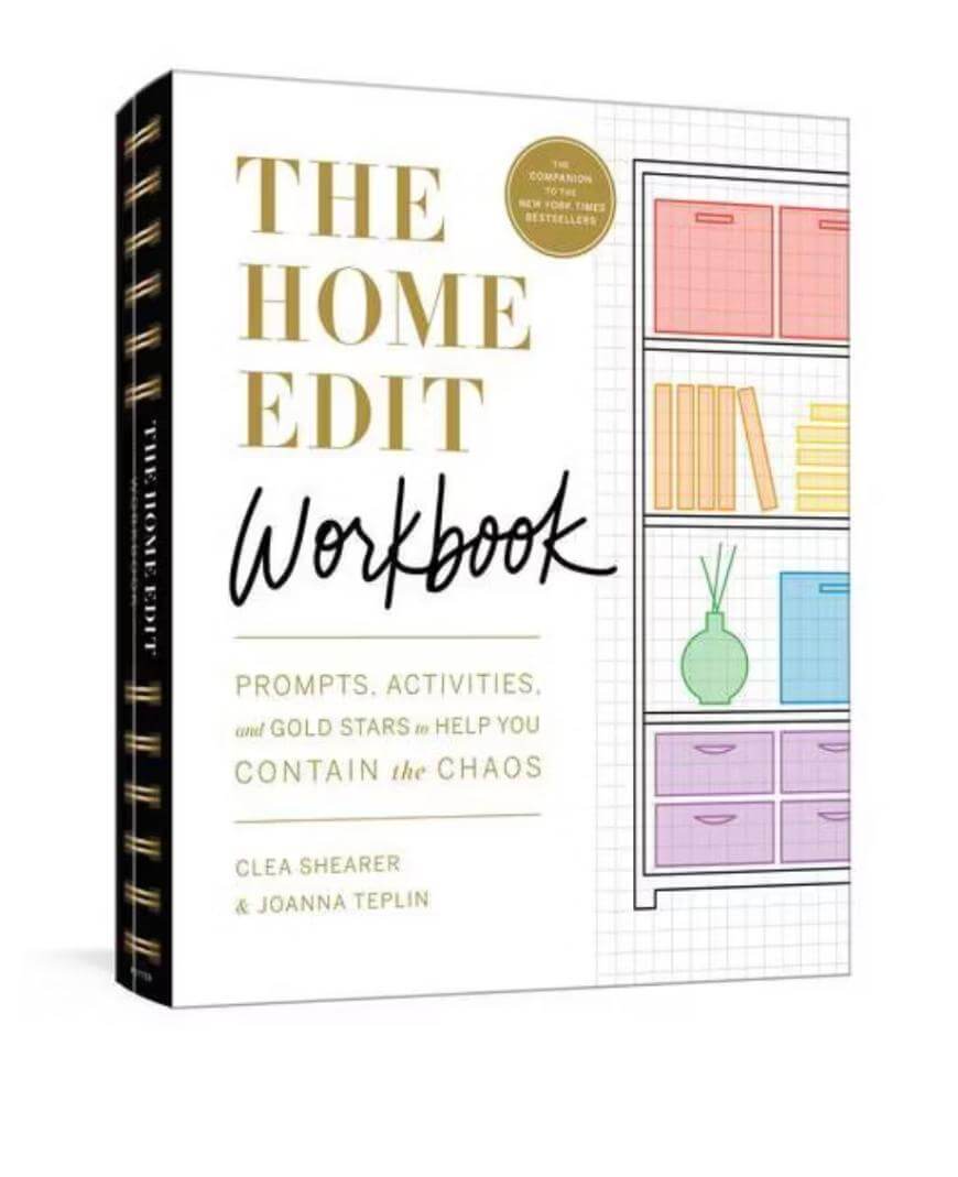 Front cover of The Home Edit Workbook by Clea Shearer and Joanna Teplin, featuring a grid background, a colorful illustrated bookshelf, and gold, black, and pastel text.