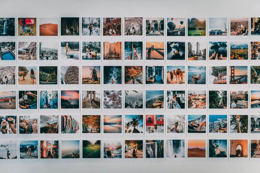 A grid of colorful, square-shaped travel photos is neatly arranged on a white wall, showcasing various landscapes, people, and cityscapes from different locations around the world.