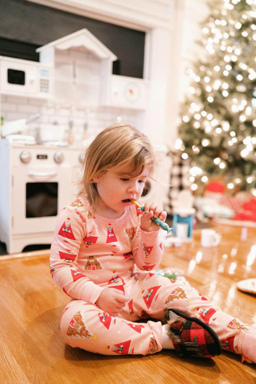 A child sitting on the floor eating candy.