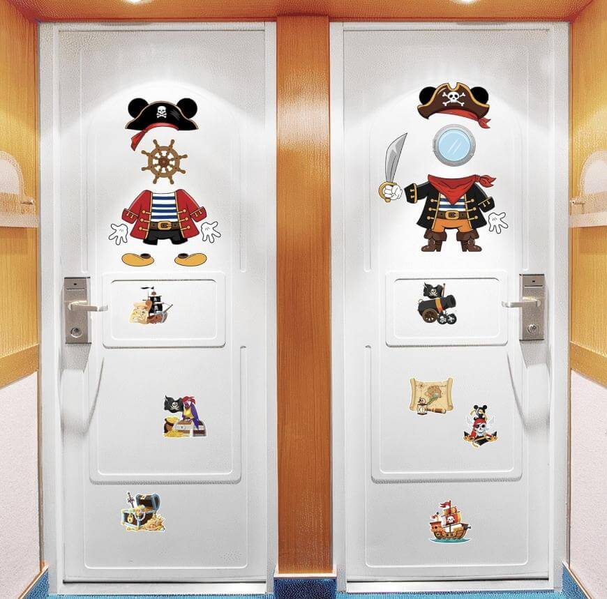 Two white doors decorated with playful pirate-themed stickers, including pirate outfits, treasure chests, maps, and pirate ships, set against a light wood-paneled hallway.