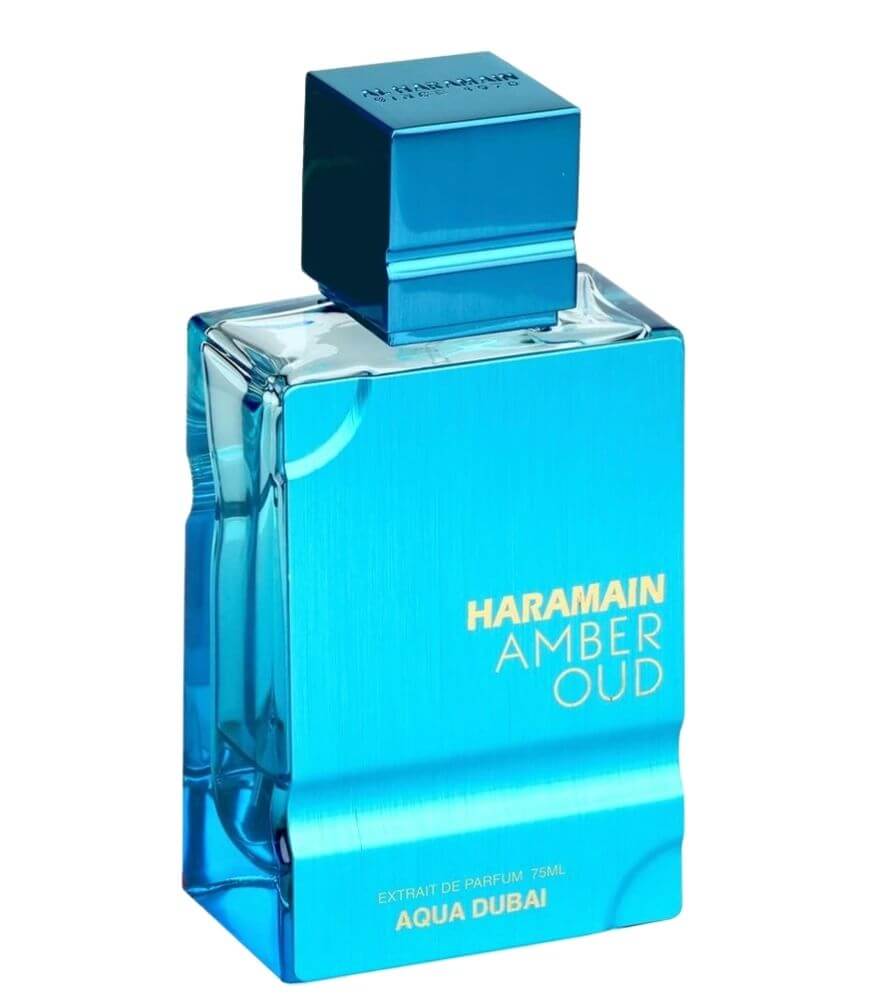 A blue rectangular perfume bottle labeled Haramain Amber Oud with Aqua Dubai written at the bottom, featuring a matching blue cap and a reflective, metallic finish.