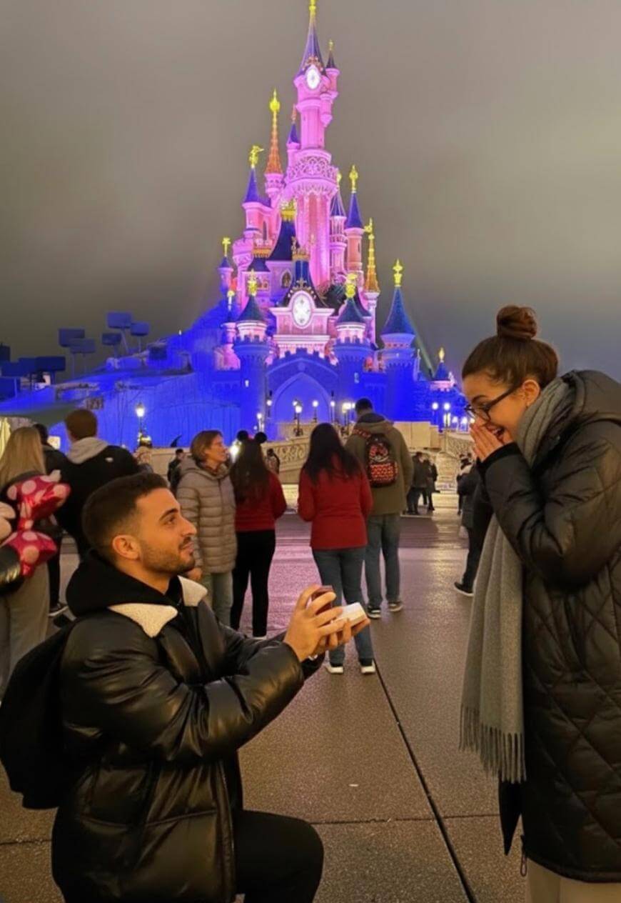 A man and woman standing in front of a castle.