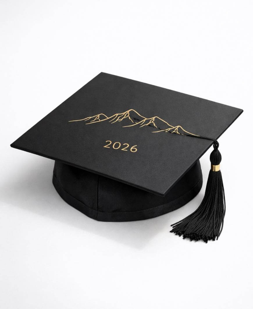 A black graduation cap with a gold outline of mountains and 2026 written in gold, featuring a black tassel with a gold band.