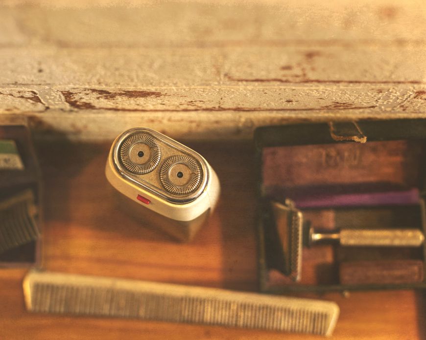 Vintage grooming tools including an electric shaver, comb, and razor