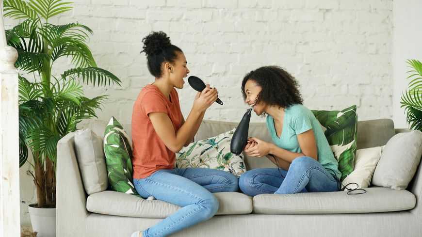 Two women relaxing and laughing together on a couch at home