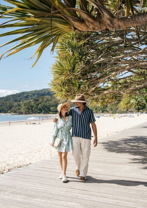 Couple walking along a beach boardwalk on a celebration trip