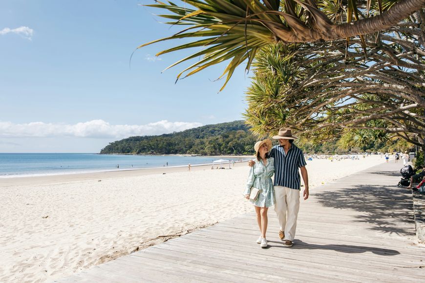 Couple walking along a beach boardwalk on a celebration trip