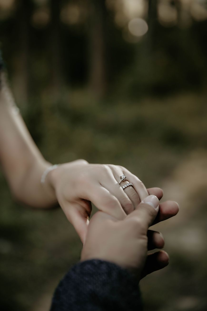 Couple holding hands with an engagement ring on her finger