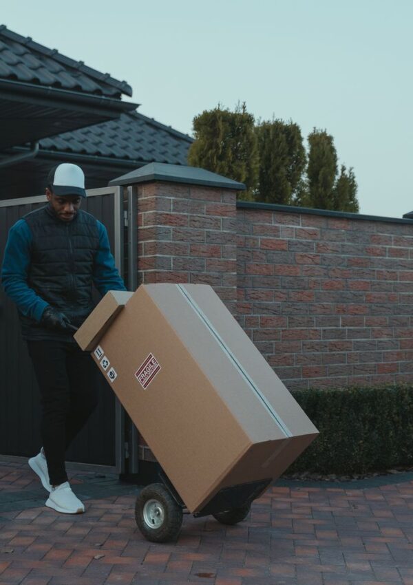 Man delivering a large boxed parcel on a hand truck